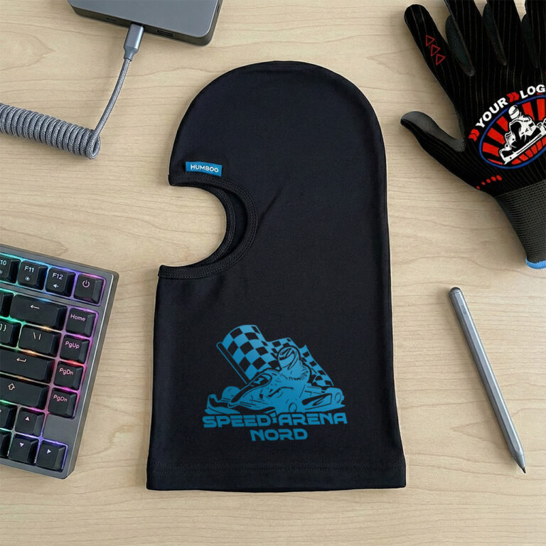 Pasamontañas negro con el logotipo «SPEED ARENA NORD», guante con el logotipo y teclado sobre la mesa.