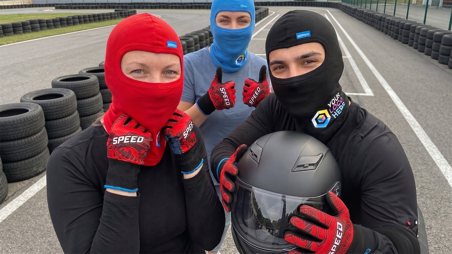 Młody kierowca gokarta w kasku i personalizowanych rękawicach nylonowych z logo - gadżety na tor kartingowy.