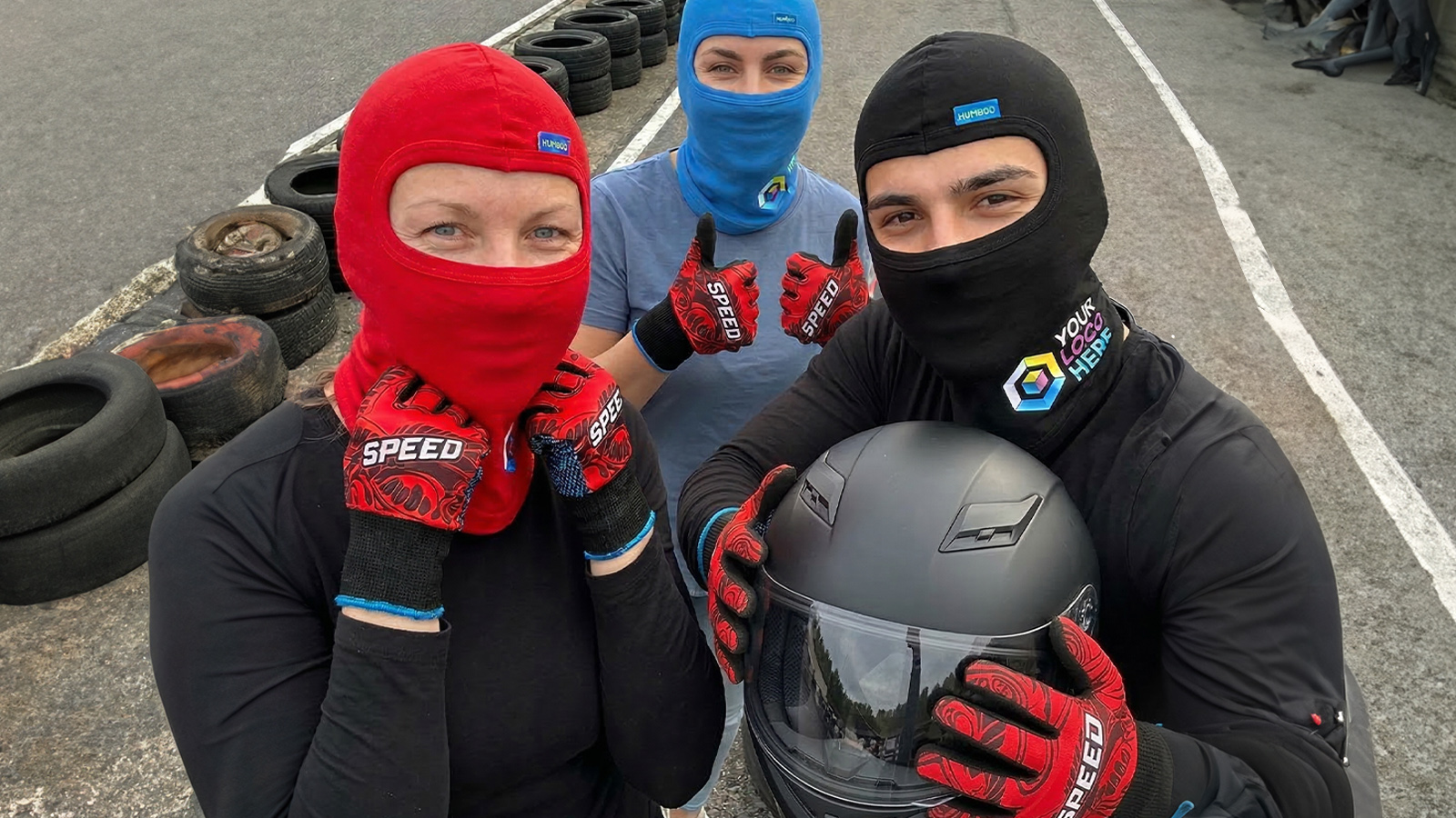 Un jeune pilote de karting portant un casque et des gants en nylon personnalisés avec un logo – accessoires pour circuit de karting.